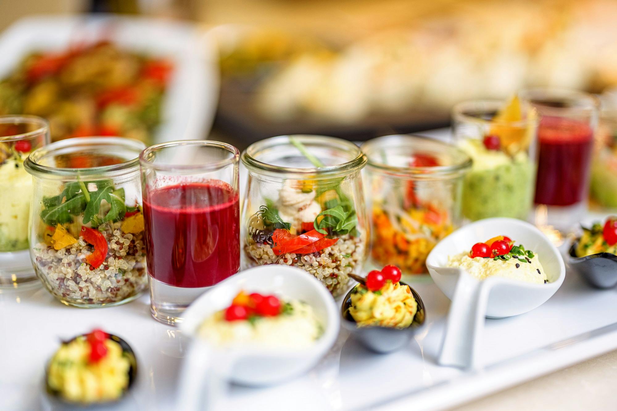 Vielfältige Auswahl an gesunden Vorspeisen in kleinen Gläsern und Schüsseln für Catering oder Eventbuffet.